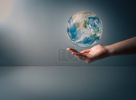 Tag der Erde, Menschliche Hand hält blaue Erde auf grauem Hintergrund, speichere Erde, von der NASA erstelltes Bild, Kopie des Weltraums .