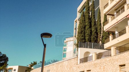 street lamp against the blue sky and cypress trees on the terrace