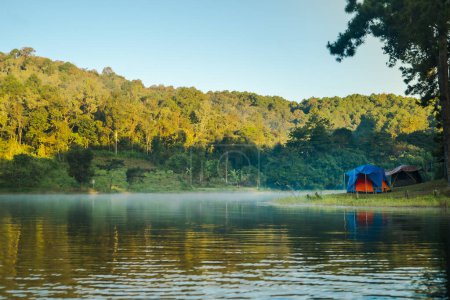 Foto de Tienda de campaña paisaje al lado del lago con niebla en la mañana en la temporada de otoño - Imagen libre de derechos