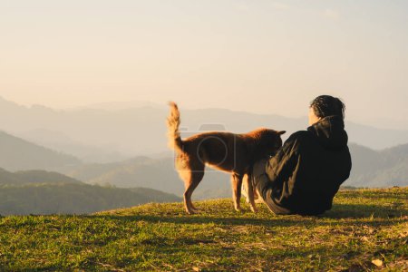 Natur mit Alleinreisenden spielen mit Hund und sehen Sonnenaufgang mit Bergschicht