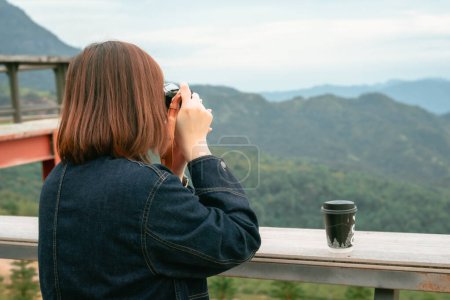 solo asiático mujer hipster viajero tomando foto a montaña en al aire libre bar de coffeeshop
