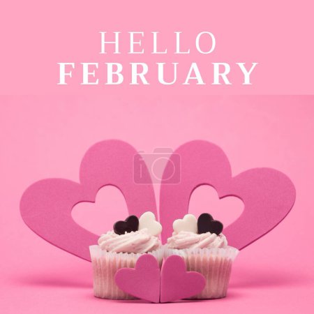 Composition of hello february text and cupcakes with hearts on pink background. February, valentine's day, love and romance concept digitally generated image.
