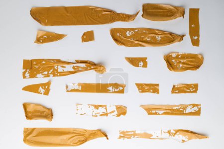 Photo for Ripped up pieces of orange tape with copy space on white background. Abstract paper texture background and communication concept. - Royalty Free Image
