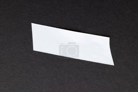 Photo for Ripped up piece of white tape with copy space on black background. Abstract paper texture background and communication concept. - Royalty Free Image