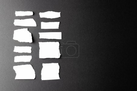 Foto de Arrancaron pedazos de papel blanco con espacio para copiar sobre fondo negro. Textura de papel abstracto fondo y concepto de comunicación. - Imagen libre de derechos