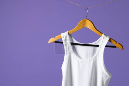 Photo for Tshirt hanging on coat hanger and copy space on purple background. Clothing, fashion and retail concept. - Royalty Free Image