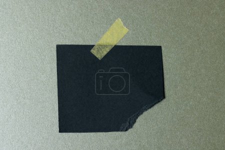 Photo for Ripped up piece of black paper with copy space on green background. Abstract paper texture background and communication concept. - Royalty Free Image