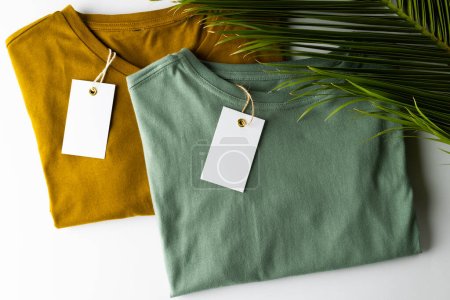 Foto de Cierre de camisetas con etiquetas y espacio de copia sobre fondo blanco. Ropa, moda y concepto de retail. - Imagen libre de derechos