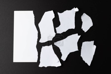 Découpé des morceaux de papier blanc avec de l'espace de copie sur fond noir. Texture abstraite du papier fond et concept de communication.