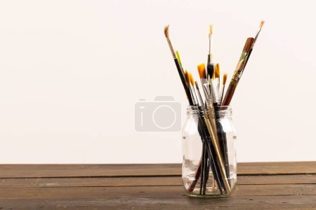 Photo for Composition of jar of painting brushes on white background. National craft month, painting, art and copy space, digital composite image. - Royalty Free Image