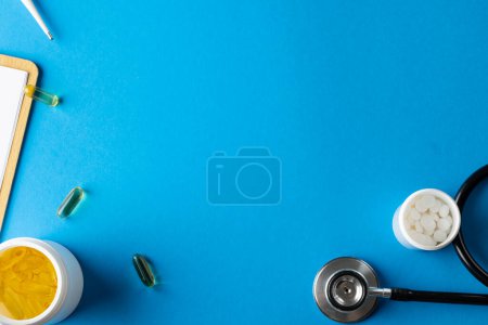 Photo for Composition of stethoscope with pills and capsules on blue background with copy space. Medical services, healthcare and health awareness concept. - Royalty Free Image