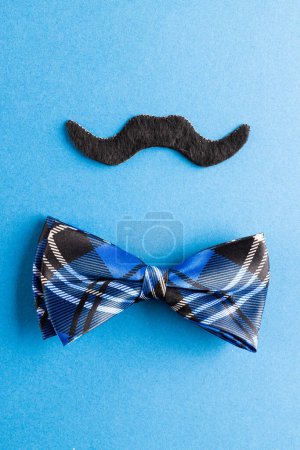 Photo for Composition of fake moustache and bow tie on blue background with copy space. Fake moustache day, party, celebration and costume concept. - Royalty Free Image