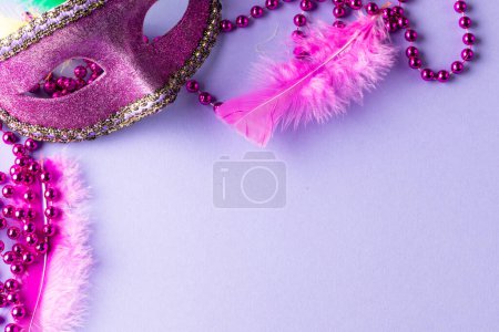 Téléchargez les photos : Composition de perles de mardi gras rose et masque de carnaval sur fond bleu avec espace de copie. Fête, célébration et concept de carnaval. - en image libre de droit