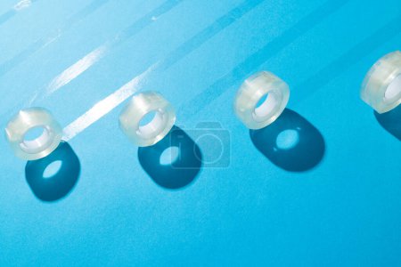 Photo for Rolls of transparent masking tape with copy space on blue background. Abstract paper texture background and communication concept. - Royalty Free Image