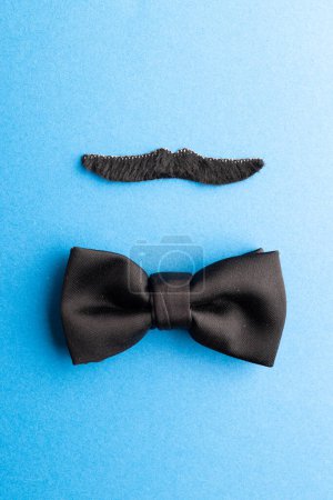 Photo for Composition of fake moustache and bow tie on blue background with copy space. Fake moustache day, party, celebration and costume concept. - Royalty Free Image