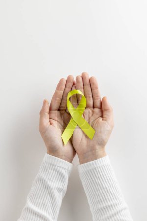 Photo for Vertical of hands holding light green std awareness ribbon on white background with copy space. Medical services, healthcare and health awareness concept. - Royalty Free Image