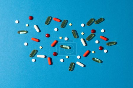 Photo for Composition of a variety of pills and capsules on blue background with copy space. Medical services, medicine, healthcare and health awareness concept. - Royalty Free Image