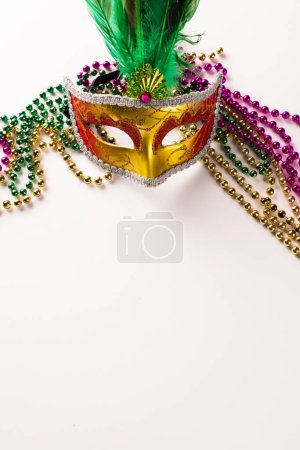 Téléchargez les photos : Composition de perles de mardi gras colorées et masque de carnaval sur fond blanc avec espace de copie. Fête, célébration et concept de carnaval. - en image libre de droit
