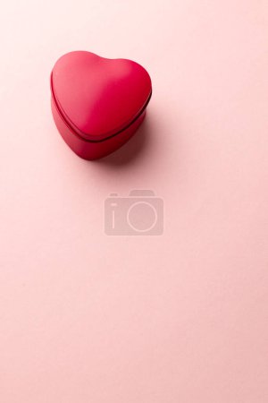 Photo for Vertical image of red heart shaped box on pale pink background with copy space. Valentine's day, love, romance and celebration concept. - Royalty Free Image