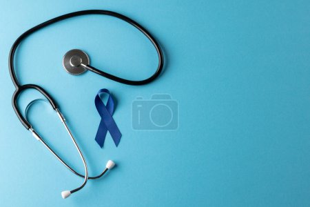 Photo for Composition of blue cancer awareness ribbon and stethoscope on blue background with copy space. Medical services, healthcare and health awareness concept. - Royalty Free Image