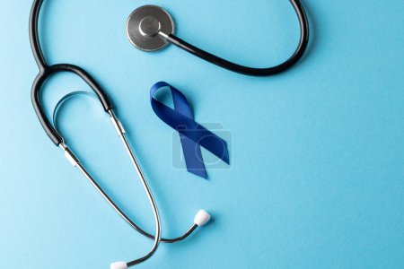Photo for Composition of blue cancer awareness ribbon and stethoscope on blue background with copy space. Medical services, healthcare and health awareness concept. - Royalty Free Image
