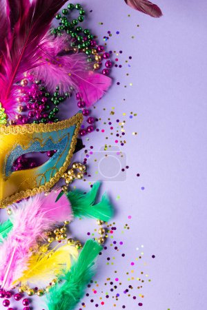 Foto de Colores granos de mardi gras, confeti, plumas y máscara de carnaval, sobre fondo azul con espacio para copiar. Fiesta, celebración y concepto de carnaval. - Imagen libre de derechos