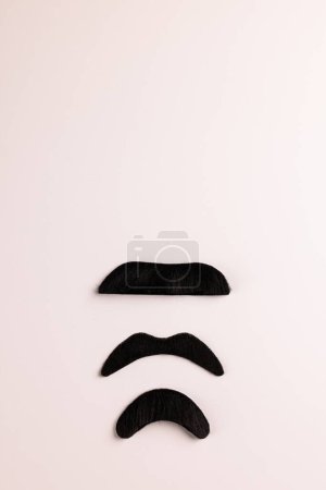 Téléchargez les photos : Composition de fausses moustaches sur fond blanc avec espace de copie. Fausse moustache jour, fête, célébration et concept de costume. - en image libre de droit