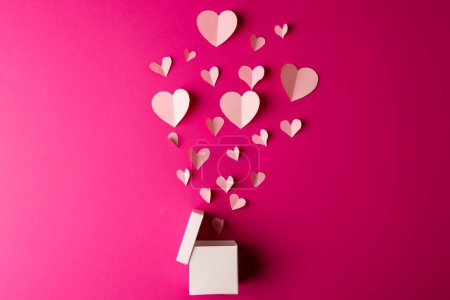 Foto de Caja de regalo blanca abierta que libera corazones blancos sobre fondo rosa con espacio para copiar. Día de San Valentín, amor, romance y concepto de celebración. - Imagen libre de derechos