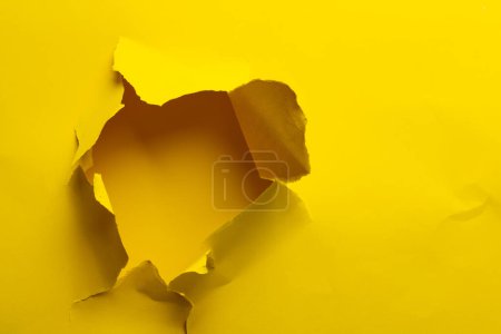 Zerrissenes Stück gelbes Papier mit Kopierraum auf gelbem Hintergrund. Abstraktes Papier Textur Hintergrund und Kommunikationskonzept.