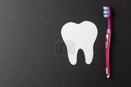 Photo for Composition of white tooth and toothbrush on black background with copy space. Medical services, healthcare and dental health awareness concept. - Royalty Free Image