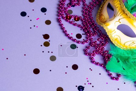 Foto de Composición de coloridas cuentas de mardi gras y máscara de carnaval sobre fondo azul con espacio para copiar. Fiesta, celebración y concepto de carnaval. - Imagen libre de derechos