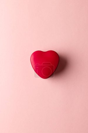 Photo for Overhead vertical image of red heart shaped box on pale pink background with copy space. Valentine's day, love, romance and celebration concept. - Royalty Free Image
