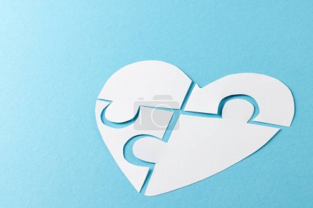 Téléchargez les photos : Composition du coeur blanc en pièces de puzzle sur fond bleu, avec espace de copie. Concept de médecine, de santé et de sensibilisation à la santé. - en image libre de droit