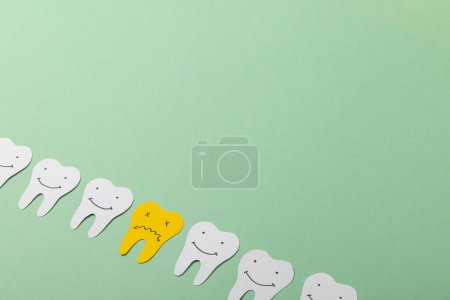 Foto de Primer plano de los dientes de papel sobre fondo verde con espacio para copiar. Concepto de medicina, salud y ciencia. - Imagen libre de derechos
