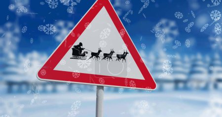 Téléchargez les photos : Des flocons de neige tombant contre le Père Noël en traîneau sont tirés par des rennes sur le panneau d'arrêt. Noël fête et concept de célébration - en image libre de droit
