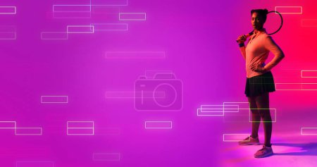 Téléchargez les photos : Vue latérale d'une joueuse de tennis biraciale debout par des rectangles éclairés sur fond violet. Raquette, espace de copie, composite, sport, compétition, jeu, match, forme et concept abstrait, - en image libre de droit