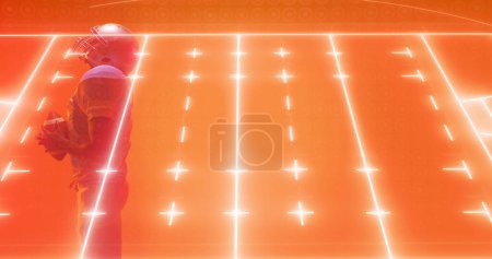 Téléchargez les photos : Composite de terrain de football américain éclairé sur joueur masculin debout sur fond orange. Espace de copie, terrain, sport, compétition, match, lumineux, illustration et concept abstrait. - en image libre de droit
