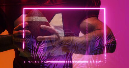 Photo for Midsection of american football player holding ball standing by illuminated rectangle and plants. Copy space, composite, african american, sport, competition, illustration, glowing, nature, shape. - Royalty Free Image