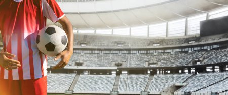Photo for Midsection of player holding soccer ball standing in stadium on sunny day, copy space. Soccer, sportsman, athlete, sport, competitive sport, match, skill, panoramic. - Royalty Free Image
