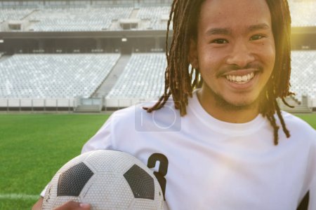 Photo for Portrait of smiling african american soccer player with ball at stadium on sunny day. Sport, competitive sport, skill, athlete, happy. - Royalty Free Image