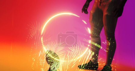 Photo for Low section of american football player with ball standing by illuminated plants and circle. Copy space, sport, competition, illustration, glowing, nature, shape and abstract concept. - Royalty Free Image