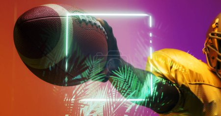 Photo for Cropped hand of american football player holding ball by illuminated square and plants, copy space. Composite, sport, competition, illustration, glowing, nature, shape and abstract concept. - Royalty Free Image