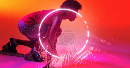 Photo for Side view of biracial female athlete at starting position by illuminated circle and plants. Copy space, composite, sprinting, sport, competition, running, racing, shape, nature and abstract concept. - Royalty Free Image
