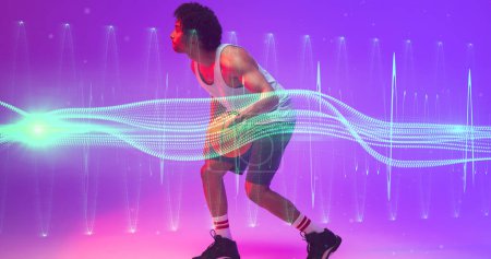 Foto de Jugador birracial masculino jugando baloncesto por zig zag iluminado y patrón de onda sobre fondo púrpura. Copiar espacio, compuesto, deporte, competición, ilustración, iluminado, forma y concepto abstracto. - Imagen libre de derechos