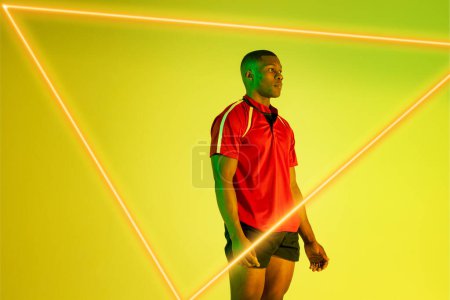 Photo for Triangle neon over thoughtful african american young sportsman standing against yellow background. Digital composite, sport, fitness, athlete, copy space, contemplation. - Royalty Free Image