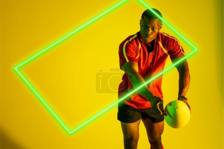 Photo for Rectangle neon over african american young rugby player playing against yellow background. Digital composite, sport, rugby, athlete, competitive sport, skill, playing, copy space. - Royalty Free Image