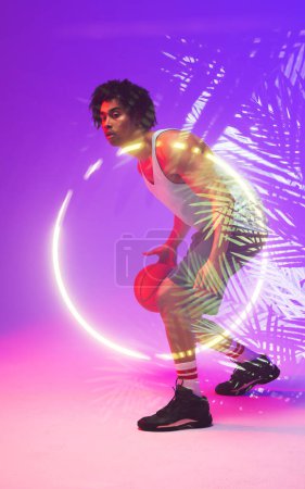 Photo for Side view of male biracial player dribbling basketball by illuminated plants and circle, copy space. Composite, sport, competition, illustration, glowing, nature and shape concept. - Royalty Free Image