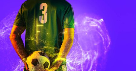 Photo for Rear view of soccer player holding ball with abstract neon in blue background, copy space. Computer graphic, copy space, digital composite, soccer, design, athlete, competitive sport. - Royalty Free Image
