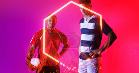 Téléchargez les photos : Composite de joueurs masculins multiraciaux debout par hexagone illuminé sur fond rose. Copier l'espace, adversaire, sport, compétition, rugby, balle, forme et concept abstrait. - en image libre de droit