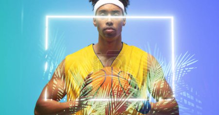 Photo for Portrait of biracial basketball player holding ball in front of illuminated rectangle and plants. Copy space, blue, composite, confident, sport, competition, illustration, glowing, nature, shape. - Royalty Free Image